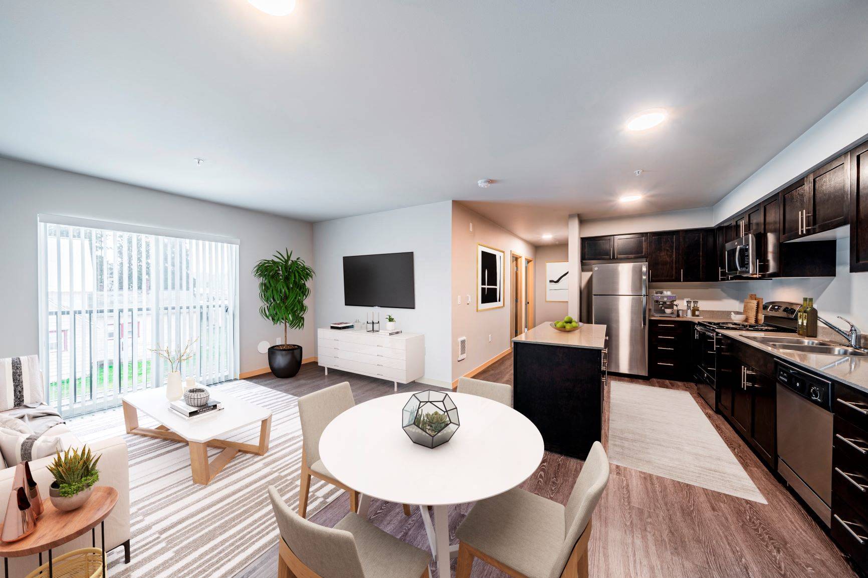 a living room with a table and a kitchen